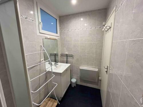 een badkamer met een wastafel, een toilet en een spiegel bij LE PETIT LOUIS AVEC LES CLES DE LUZ in Saint-Jean-de-Luz
