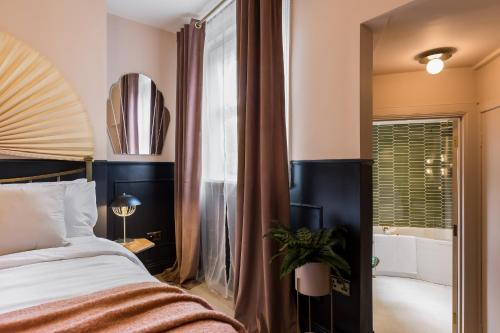 een slaapkamer met een bed, een bad en een raam bij Stylish Central Apartment in Bournemouth