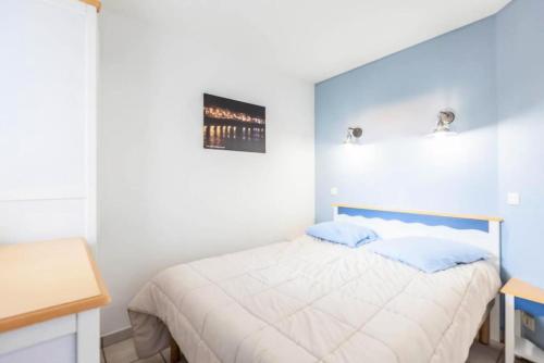 - une chambre avec un lit blanc aux murs bleus dans l'établissement Résidence Port Bourgenay - maeva Home - 2 Pièces 5 Personnes Sélection MAE-2102, à Talmont-Saint-Hilaire