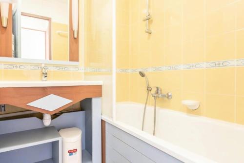 une salle de bain avec un lavabo, une baignoire et un miroir dans l'établissement Résidence Port Bourgenay - maeva Home - 2 Pièces 5 Personnes Sélection MAE-2102, à Talmont-Saint-Hilaire
