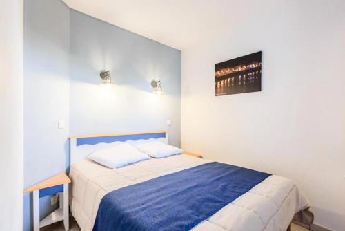 - une petite chambre avec un lit bleu et blanc dans l'établissement Résidence Port Bourgenay - maeva Home - 2 Pièces 5 Personnes Sélection MAE-2103, à Talmont-Saint-Hilaire