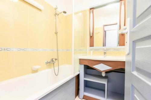 une salle de bain avec un lavabo, une baignoire et un miroir dans l'établissement Résidence Port Bourgenay - maeva Home - 2 Pièces 5 Personnes Sélection MAE-2103, à Talmont-Saint-Hilaire