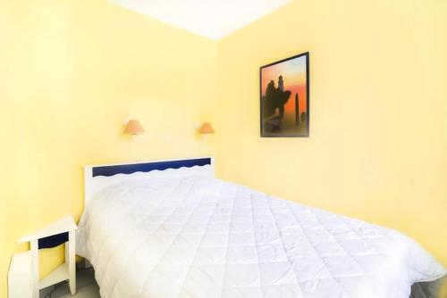 - une chambre avec un lit blanc et une photo sur le mur dans l'établissement Résidence Port Bourgenay - maeva Home - 2 Pièces 5 Personnes Confort MAE-2110, à Talmont-Saint-Hilaire