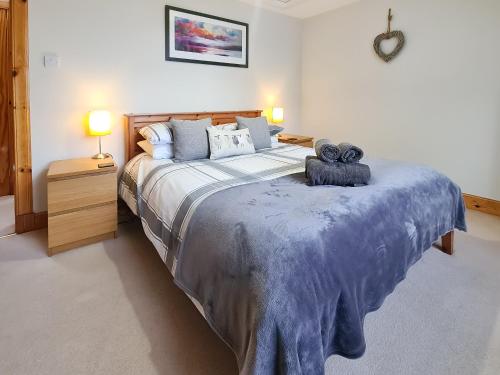 a bedroom with a large bed with two teddy bears on it at Station Cottage in Trinafour