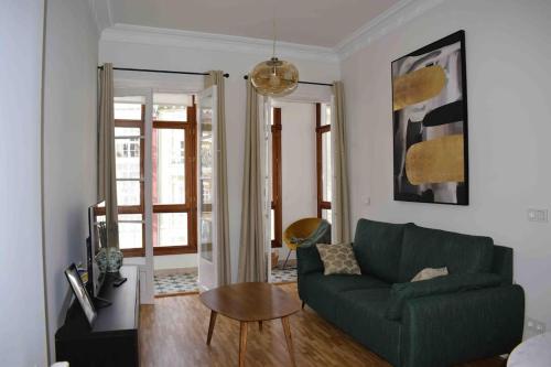 a living room with a green couch and a table at Los Magnolios de Laín Calvo in Burgos