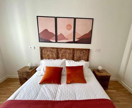 a bedroom with a bed with two red pillows at Los Magnolios de Laín Calvo in Burgos