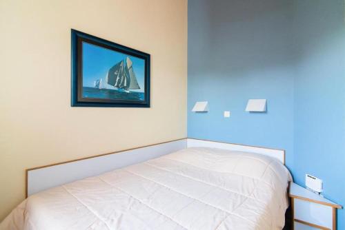 une chambre avec un lit avec un tableau sur le mur dans l'établissement Résidence Port Bourgenay - maeva Home - 2 Pièces 5 Personnes Sélection MAE-2109, à Talmont-Saint-Hilaire