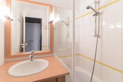 une salle de bain avec un lavabo, une douche et un miroir dans l'établissement Résidence Port Bourgenay - maeva Home - 2 Pièces 5 Personnes Sélection MAE-2109, à Talmont-Saint-Hilaire