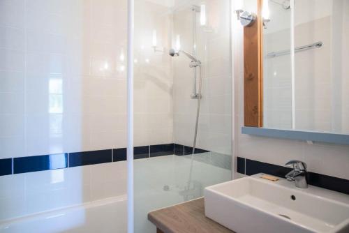 une salle de bain blanche avec un lavabo et une douche dans l'établissement Résidence Port Bourgenay - maeva Home - 2 Pièces 5 Personnes Sélection MAE-2121, à Talmont-Saint-Hilaire
