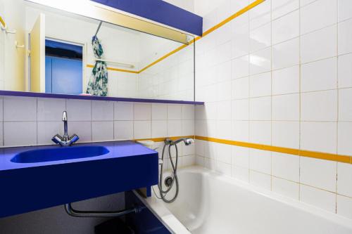 La salle de bains est pourvue d'un lavabo bleu et d'une baignoire. dans l'établissement Résidence le Village de Cap Esterel - maeva Home - Appartement 2 Pièces 5 Personnes - Confort MAE-2137, à Saint-Raphaël