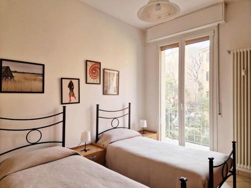 2 camas en un dormitorio con ventana en HomeSerra 2, en Bolonia