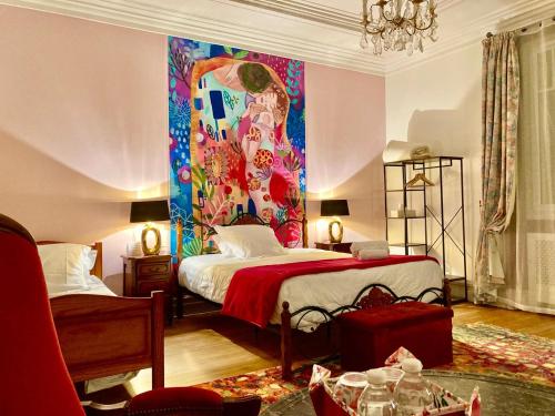 Habitación con cama y pintura en la pared en La Villa des Roses Gîte Chambres d'hôtes Piscine chauffée, en Luçon