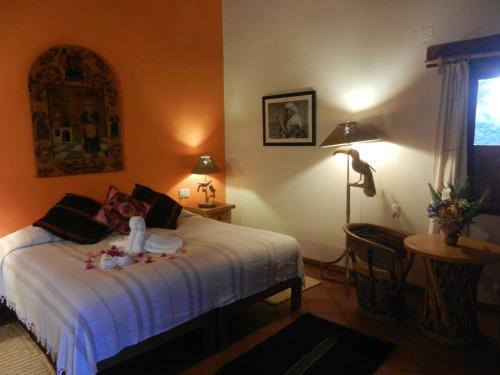 a bedroom with a bed and a table and a lamp at Posada Yolihuani in Pátzcuaro