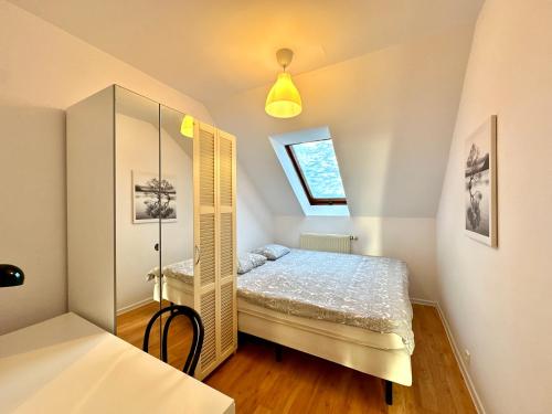 um pequeno quarto com uma cama e um espelho em Mieszkanie rodzinne Gdynia Mały Kack em Gdynia