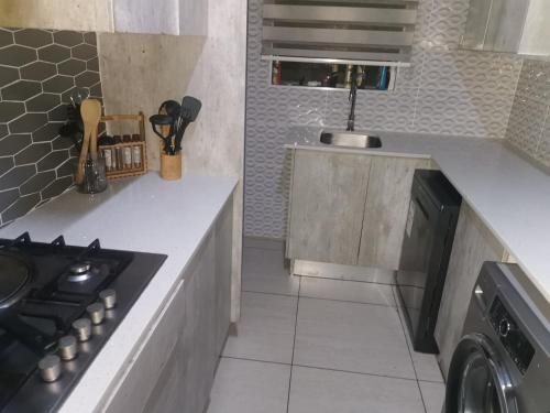 a kitchen with a stove top oven next to a counter at Sagewood Manor in Midrand