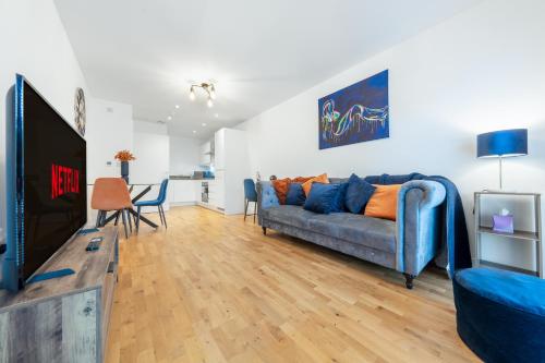 a living room with a blue couch and a table at Luxury 1 Bedroom Apartment In Stevenage Town With Balcony in Stevenage