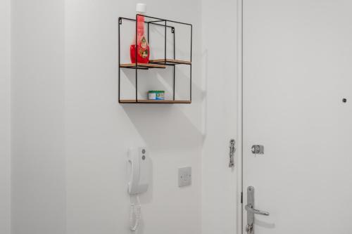uma casa de banho com chuveiro e uma prateleira na parede em Luxury 1 Bedroom Apartment In Stevenage Town With Balcony em Stevenage