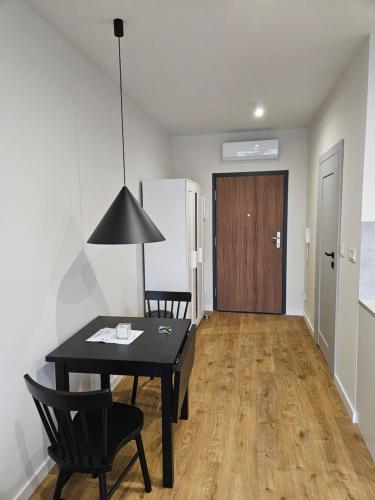 een kamer met een zwarte tafel en stoelen en een deur bij Apartamenty Orawska 14 in Krakau