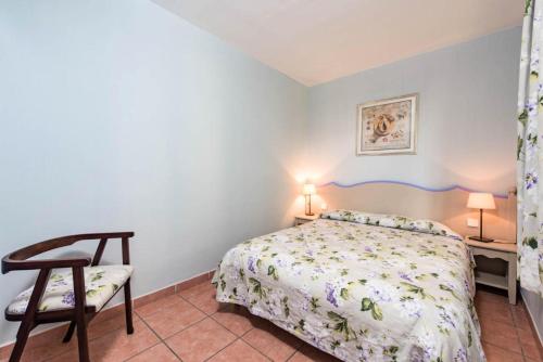 une chambre avec un lit et une chaise dans l'établissement Résidence Les Rives de Cannes Mandelieu - maeva Home - 2 Pièces 5 Personnes Prestige MAE-2168, à Mandelieu-la-Napoule