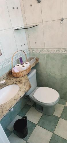 a bathroom with a toilet and a sink and a basket at Apê perto Alphaville in Osasco