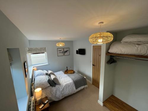 特尔福德The Poplars - Cosy Modern Flat with Great Networking的一间卧室配有一张床、两盏灯和一张床。