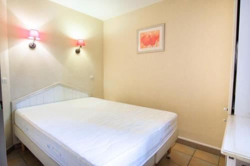 - une chambre avec un lit blanc et deux lumières sur le mur dans l'établissement Village Moliets - maeva Home - 2 Pièces 5 Personnes Confort MAE-2172, à Moliets-et-Maa