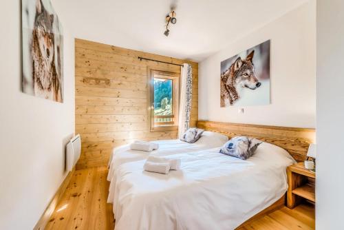 deux lits dans une chambre aux murs en bois dans l'établissement Résidence Les Balcons EtoilÉs - Appartement 4 au pied des pistes MAE-4144, à Champagny-en-Vanoise