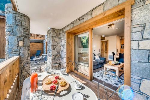 une table et des chaises dans une pièce avec un mur en pierre dans l'établissement Résidence Les Balcons EtoilÉs - Appartement 4 au pied des pistes MAE-4144, à Champagny-en-Vanoise