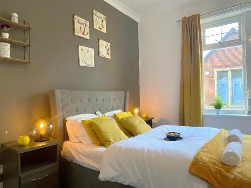 a bedroom with a bed with yellow pillows and a window at HNFC Stays - Ideal for Business Travellers -2b in Gateshead