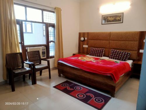 um quarto com uma cama grande e 2 cadeiras em KAMAKSHI GUEST HOUSE em Baijnāth