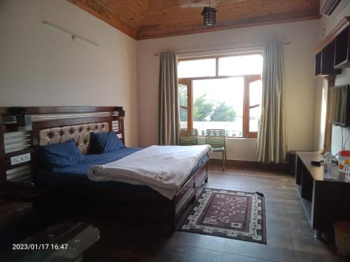 um quarto com uma cama e uma grande janela em KAMAKSHI GUEST HOUSE em Baijnāth