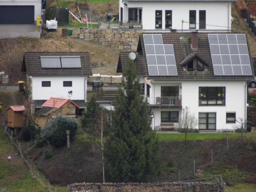 a house with solar panels on its roof at Ferienwohnung Hof 22 in Hilchenbach