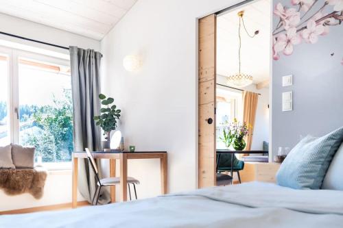 Schlafzimmer mit einem Bett, einem Schreibtisch und einem Fenster in der Unterkunft Exklusives Design-Apartment & Sauna in Warngau