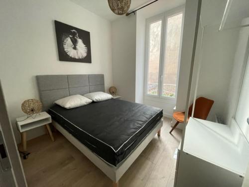 une chambre avec un grand lit dans une pièce dans l'établissement COMBOUL, à Nice