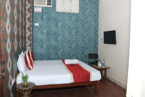 1 dormitorio con cama y pared con papel pintado verde en Hotel New Agarwal, en Jhunjhunūn