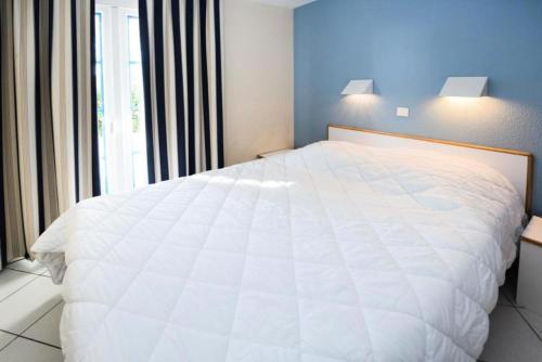 un lit blanc dans une chambre avec une fenêtre dans l'établissement Résidence Port Bourgenay - maeva Home - 2 Pièces 4 Personnes Sélection MAE-2221, à Talmont-Saint-Hilaire