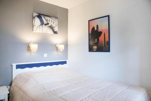 une chambre avec un lit et deux tableaux au mur dans l'établissement Résidence Port Bourgenay - maeva Home - Appartement 2 pièces 6 personnes en rez de jardin - Prestige - super Home MAE-2223, à Talmont-Saint-Hilaire