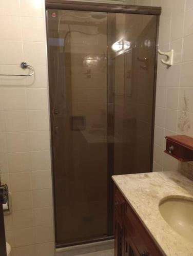 a shower with a glass door in a bathroom at Apartamento no Centro de São Lourenço in São Lourenço