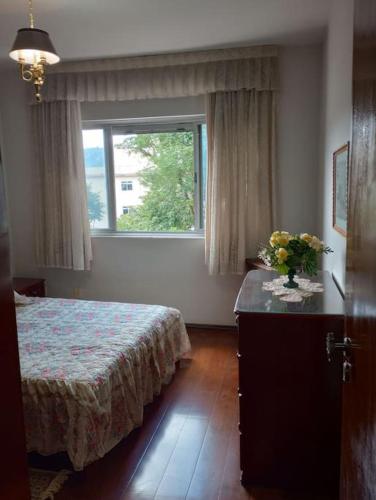 a bedroom with a bed and a window at Apartamento no Centro de São Lourenço in São Lourenço