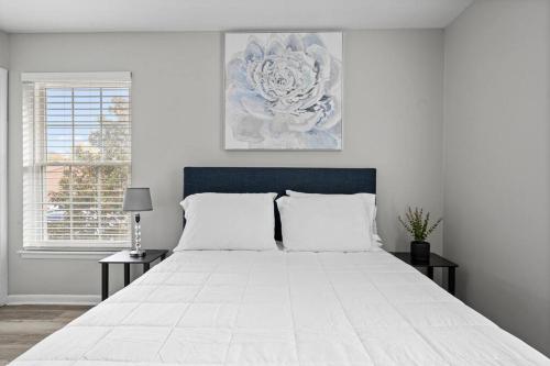 a bedroom with a large white bed with a blue headboard at Lovely 1 bedroom apartment located in Greenhills. in Nashville
