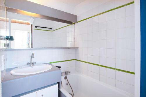 une salle de bain blanche avec un lavabo et une baignoire dans l'établissement Résidence Port Bourgenay - maeva Home - Appartement duplex 2 Pièces 6 Personnes - Sélection MAE-2227, à Talmont-Saint-Hilaire