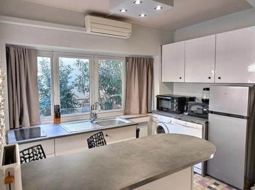 une cuisine avec un réfrigérateur blanc et un évier dans l'établissement Mouss, à Valras-Plage