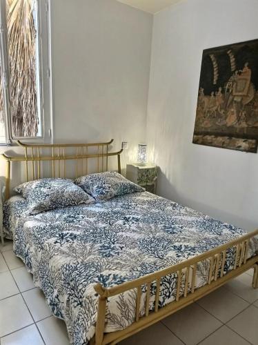 une chambre avec un lit avec une couette bleue et blanche dans l'établissement Mouss, à Valras-Plage