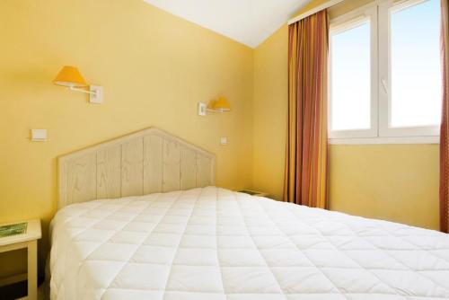 une chambre avec un grand lit blanc avec une fenêtre dans l'établissement Village Pont Royal en Provence - maeva Home - Appartement 2 Pièces 7 Personnes Confort MAE-2253, à Mallemort