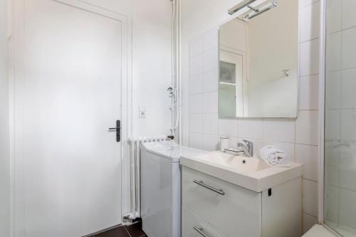 une salle de bain blanche avec un lavabo et un miroir dans l'établissement Hamac Suites - Suite Crillon, à Lyon