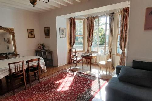 un salon avec un lit, une table et des chaises dans l'établissement Gite au château, à Castelnau-sur-Gupie