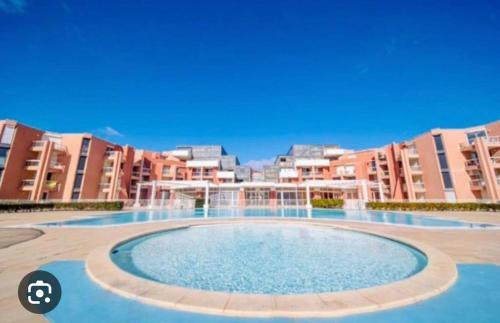 une grande piscine devant certains immeubles d'habitation dans l'établissement Appartement en front de mer, à Sète
