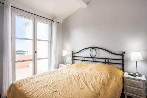 une chambre avec un lit et une grande fenêtre dans l'établissement Les Bastides aux Restanques du Golfe de St Tropez - maeva Home - Bastide 3 pièces 6 personnes avec splendide vue mer - Prestige - Super Home MAE-2257, à Grimaud