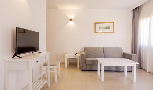 a living room with a couch and a tv at Ilunion Sancti Petri in Chiclana de la Frontera