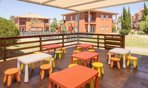 a deck with colorful tables and stools at Ilunion Sancti Petri in Chiclana de la Frontera